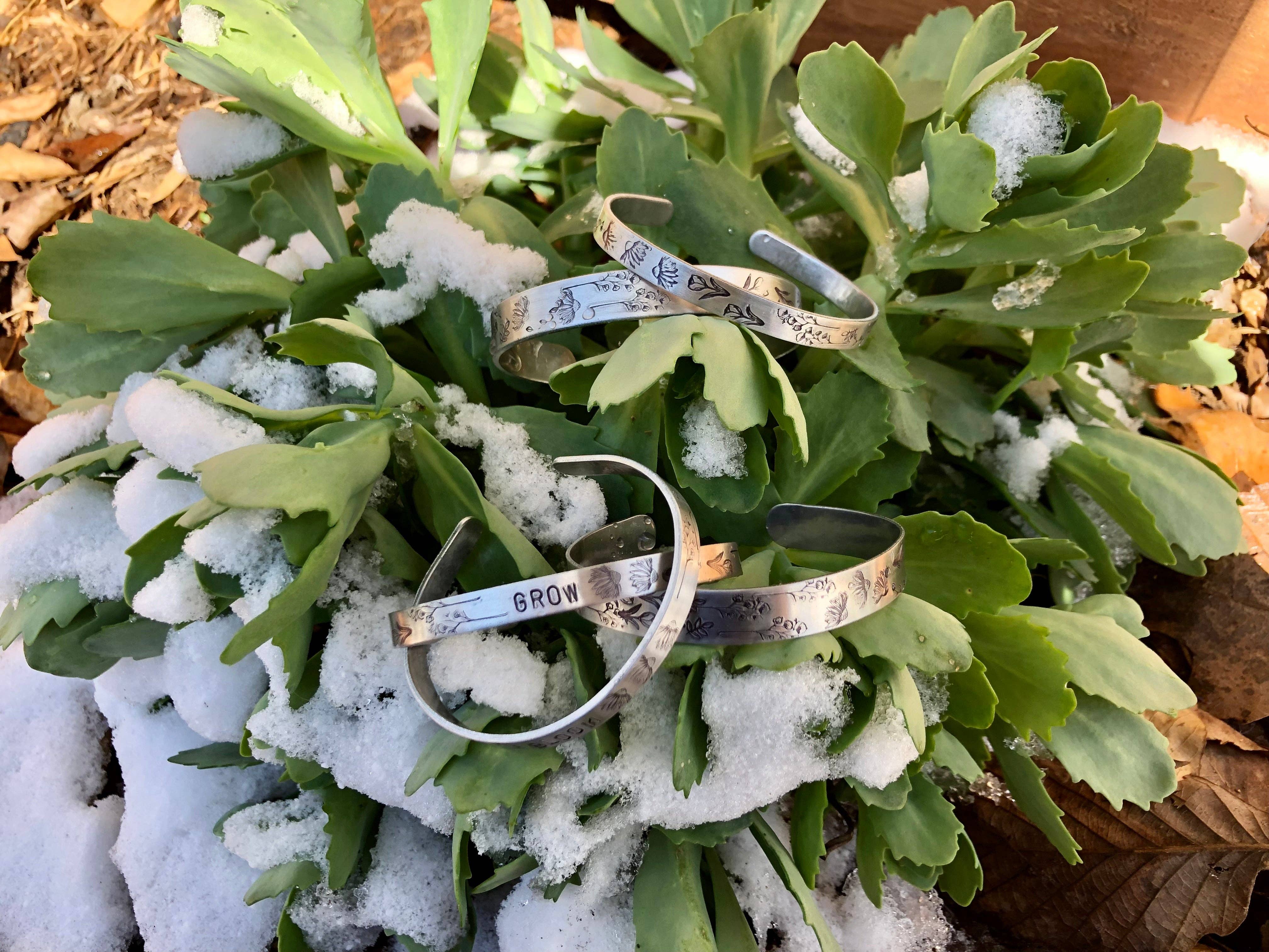 Silver cuff bracelet with hand stamped wildflower pattern