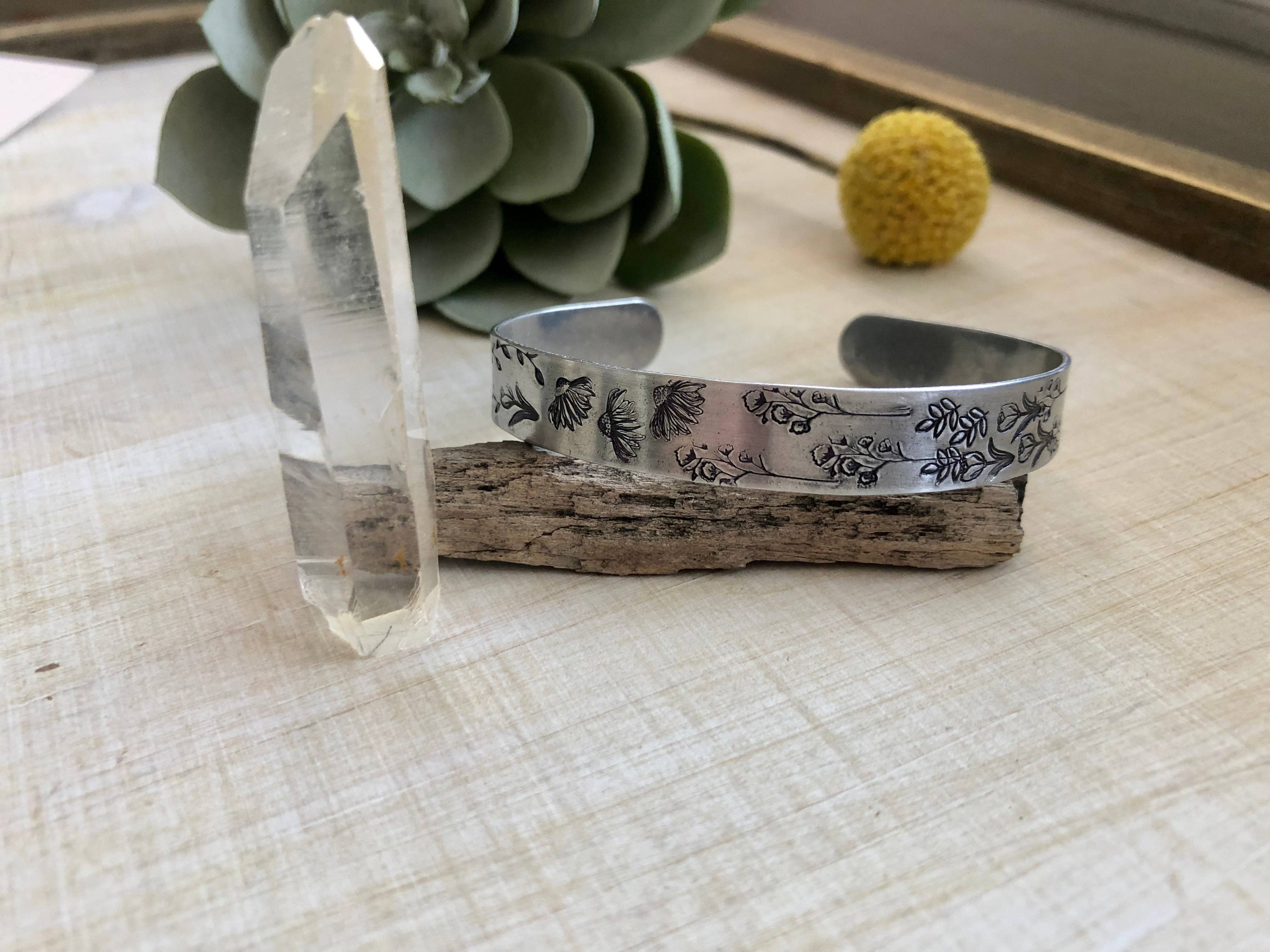 Silver cuff bracelet with hand stamped wildflower pattern