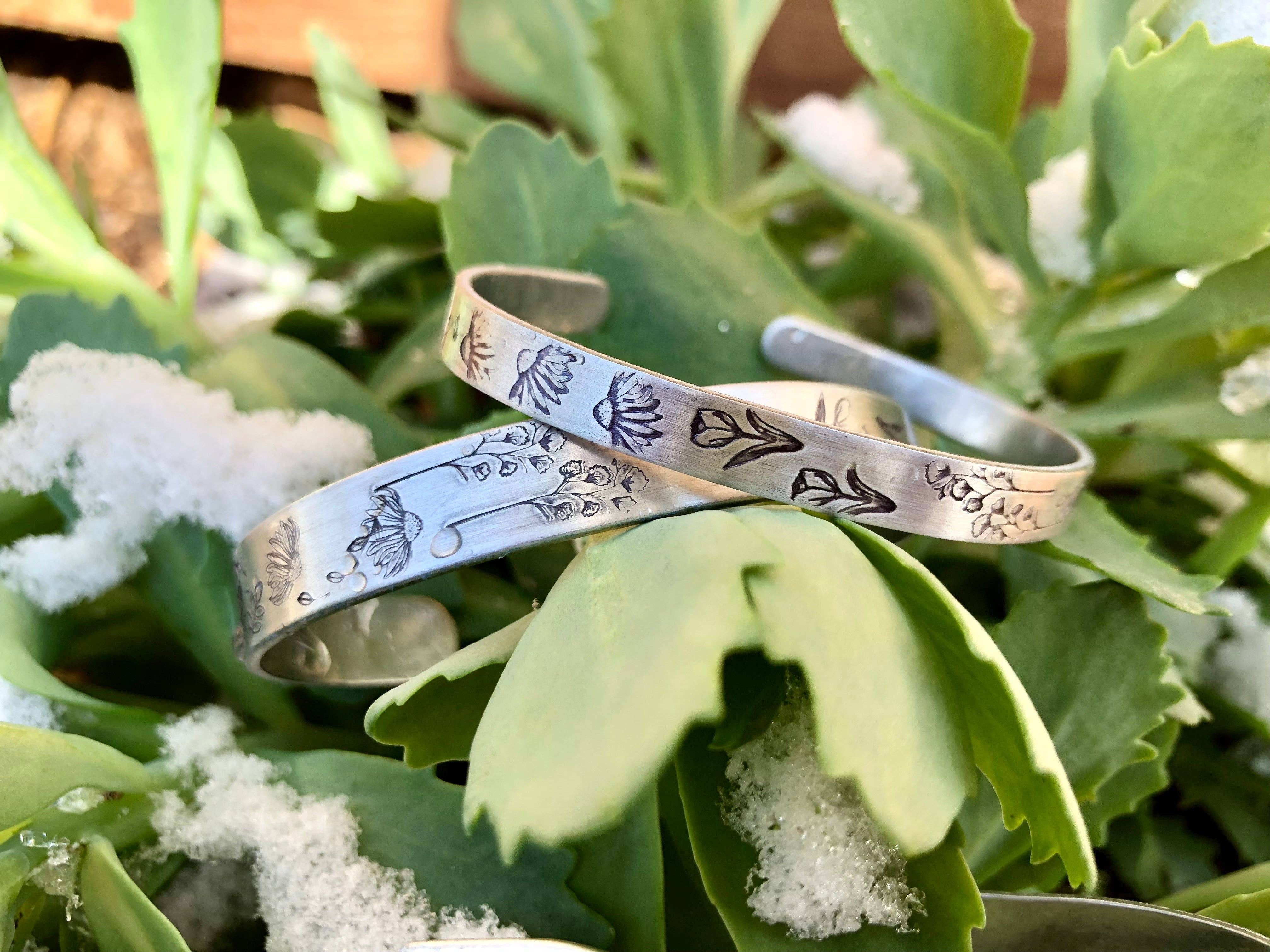 Silver cuff bracelet with hand stamped wildflower pattern