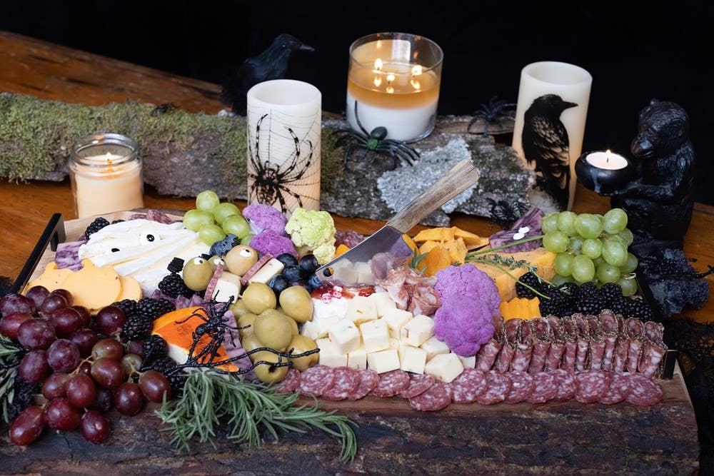 Accessories & Crocks - Gathering Boards: Seasonal Cheese And Charcuterie Spreads
Image with grapes, raspberries, blackberries, cheese, olives, and hard salami with a knife ad candles in a still life product shot setting.