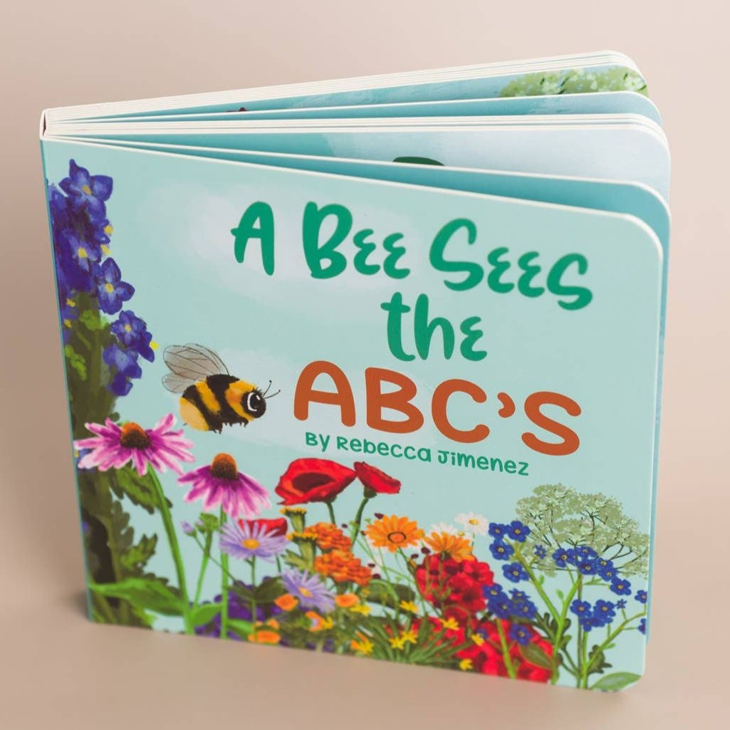 Honey - A Bee Sees The ABC's Baby Board Book view from above with pages splayed out. Book by Rebecca Jimenez.