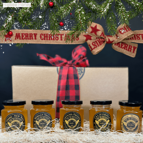 Higbee Honey Gift set with five 6 ounce jars of  Local Pure raw Unfiltered Honey with a bow and pine bough window dressing still life product photograph.